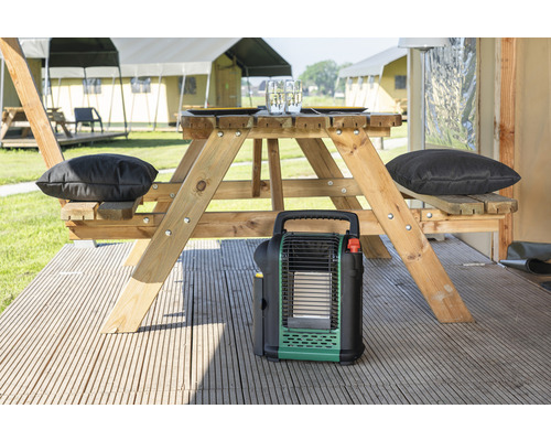 Campingplatzszene mit Picknicktisch, Kissen und tragbarer Heizung