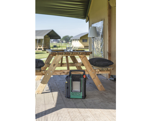 Szene mit Tischgarnitur, Heizgerät und Zelten im Hintergrund