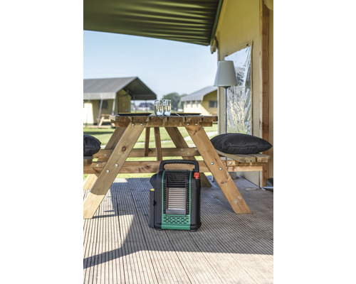 Campingplatz-Szene mit Picknicktisch, Campingheizung und Zelten im Hintergrund.