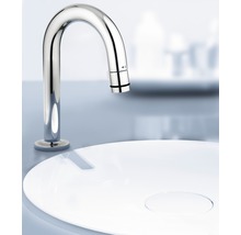 Waschtischarmatur aus Metall über einem weißen Waschbecken