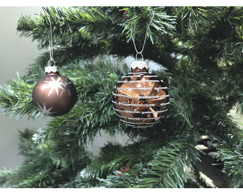 Zwei Christbaumkugeln mit Dekor hängen an einem Weihnachtsbaum.