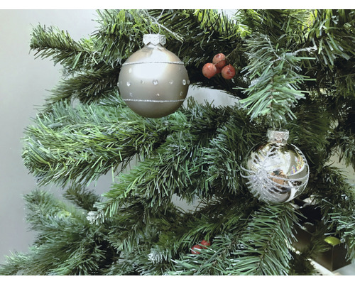 Weihnachtsbaum mit zwei Christbaumkugeln und roten Beeren
