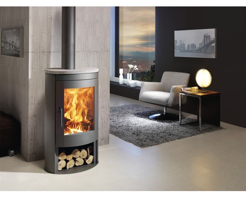 Wohnzimmer mit Kaminofen, Sessel und Beistelltisch