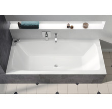 Rechteckige Badewanne im Badezimmer mit Armaturen und Ablagefläche