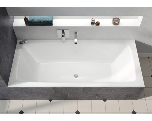 Rechteckige Badewanne im Badezimmer mit Armaturen und Ablagefläche