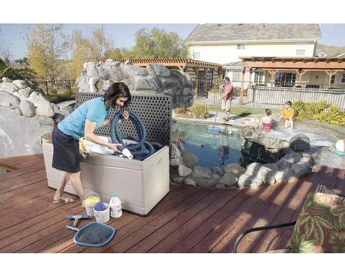 "Szene im Freien mit einer Frau, die eine Aufbewahrungsbox für Poolzubehör auf einer Holzterrasse am Pool befüllt
