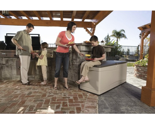 Familie beim Grillen im Garten mit einer Aufbewahrungsbox als Sitzgelegenheit