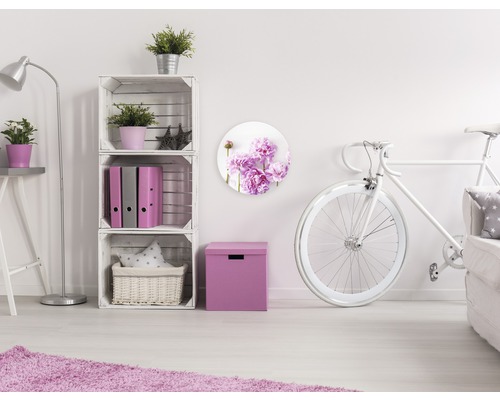 Dekorative Wohnrauminszenierung mit weißen Möbeln und Wandbild mit Blumenmotiv.