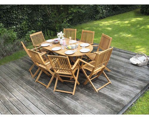 Gartenszene mit ovalem Esstisch aus Holz und acht Holzstühlen auf einer Terrasse