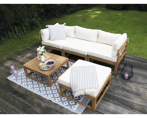 Gartenlounge-Set mit Sofa, Tisch und Hocker auf einer Terrasse
