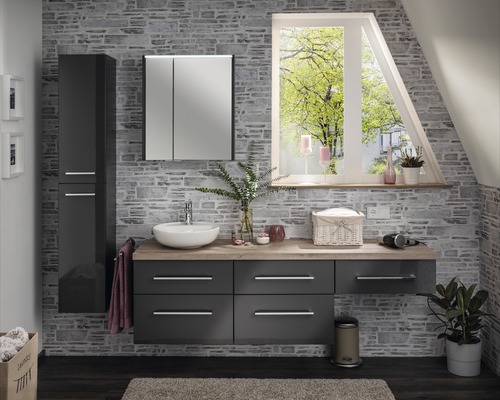 Modernes Badezimmer mit Waschtisch, Spiegelschrank und Hochschrank vor einer Steinwand