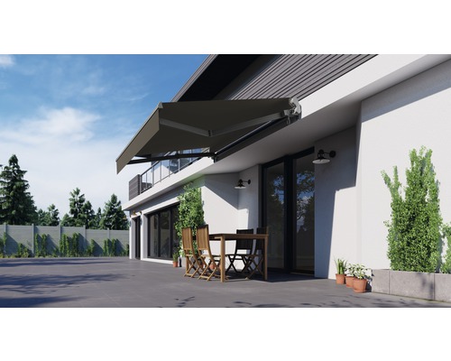 Hausfassade mit Markise über einer Terrasse mit Sitzgruppe