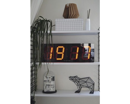 Regale mit Digitaluhr, Dekoration und Pflanze