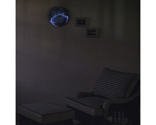 Wohnzimmer mit Sessel, Fußhocker und leuchtender Wanduhr