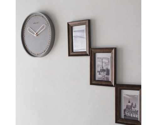 Wanduhr und drei Fotorahmen an einer Wand