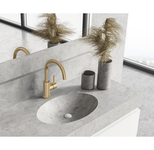 Modernes Badezimmer mit Betonwaschbecken und goldener Armatur