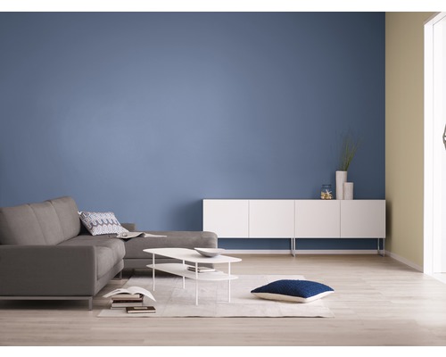Helles Wohnzimmer mit grauer Couch, weißem Lowboard und blauer Wand