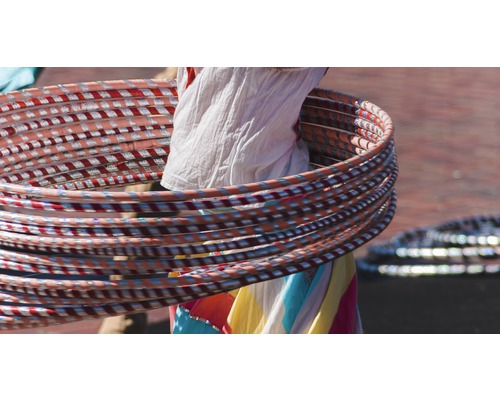 Mehrere Hula-Hoop-Reifen werden um eine Person gedreht.
