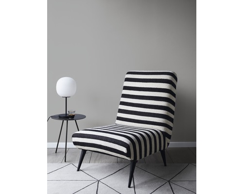 Sessel mit horizontalem Streifenmuster neben einem kleinen Tisch mit Lampe.