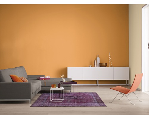 Wohnzimmer mit grauer Couch, weißem Sideboard und farbiger Wandgestaltung