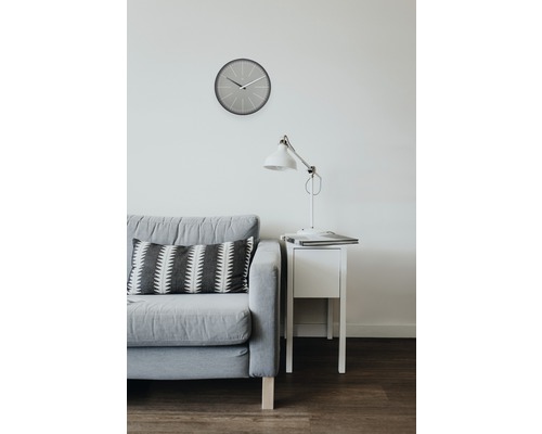 Wohnzimmer-Szene mit Sofa, Kissen, Uhr, Lampe und Nachttisch