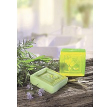 Zwei Seifenstücke mit Kräutern auf Holzuntergrund