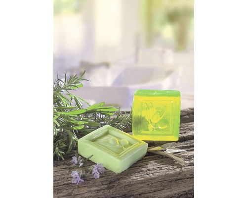 Zwei Seifenstücke mit Kräutern auf Holzuntergrund