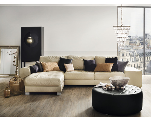 Wohnzimmer mit Ecksofa, Couchtisch, Schrank, Stehlampe und Dekoration