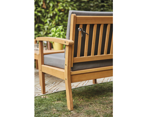 Hölzerne Gartenbank mit grauen Sitzkissen und Rückenlehne im Außenbereich