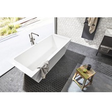 Badezimmer mit rechteckiger Badewanne, Armatur und sechseckigen Bodenfliesen.