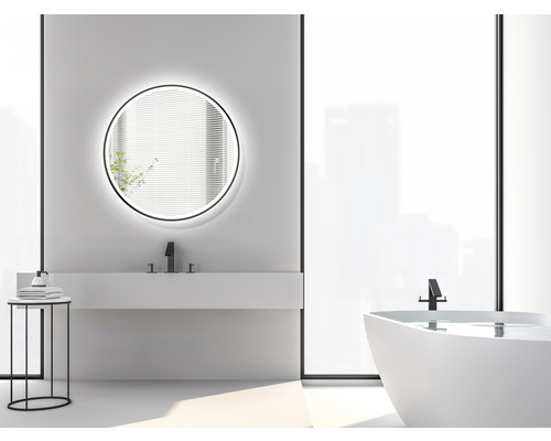 Helles Badezimmer mit rundem Spiegel, Waschbecken, Badewanne und Beistelltisch