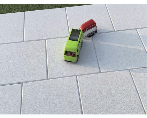 Graue Pflastersteine mit Spielzeugauto und Anhänger