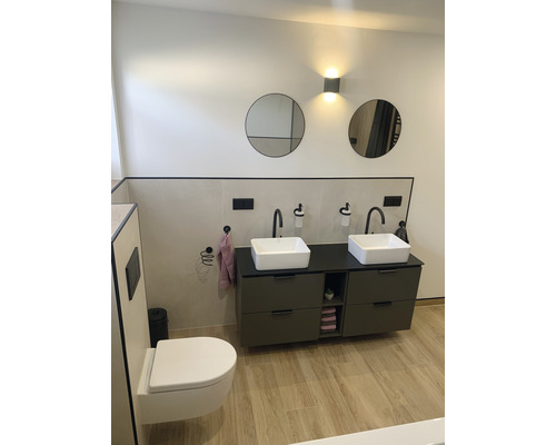 Modernes Badezimmer mit Doppelwaschtisch, runden Spiegeln und Wandleuchten