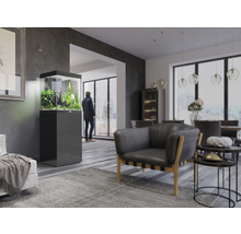 Wohnzimmer mit Aquarium auf Unterschrank, Sessel und Esstisch.