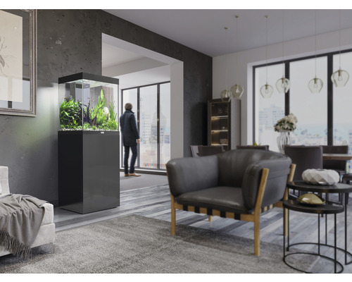 Wohnzimmer mit Aquarium auf Unterschrank, Sessel und Esstisch.