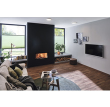 Wohnzimmer mit Kamin, Sofa, Fernseher und Holzboden für eine gemütliche Atmosphäre