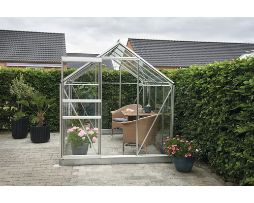 Gewächshaus mit Pflanzen und Möbeln im Garten