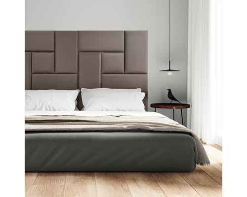 Schlafzimmer mit gepolstertem Bettkopfteil, Nachttisch und Lampe