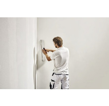 Ein Mann glättet eine Wand mit einer Glättkelle.