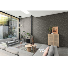 Wohnzimmer mit grauem Sofa, Kaminofen, Holzschrank und strukturierten Tapeten