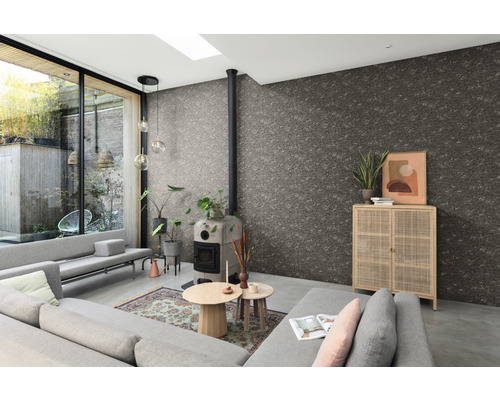 Wohnzimmer mit grauem Sofa, Kaminofen, Holzschrank und strukturierten Tapeten