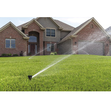 Rasenbewässerung vor einem Wohnhaus mit Rasensprengern