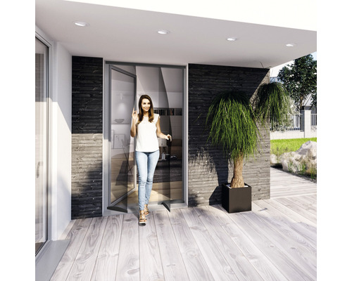 Frau betritt ein Haus mit einer Schiebetür aus Glas