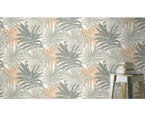 Tapete mit Palmenblattmuster und Bücherstapel auf einem kleinen Tisch
