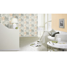 Wohnzimmer mit Palmenblatt-Tapete, Sofa, Tisch und Lampe