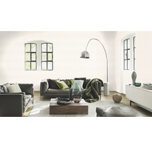 Wohnzimmer mit Sofa, Sessel, Holztisch, Stehlampe und zwei Fenstern.