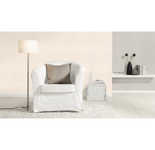Wohnzimmer mit Sessel, Stehlampe und dekorativen Elementen auf einem Regal.