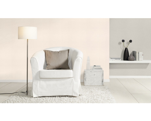 Wohnzimmer mit Sessel, Stehlampe und dekorativen Elementen auf einem Regal.