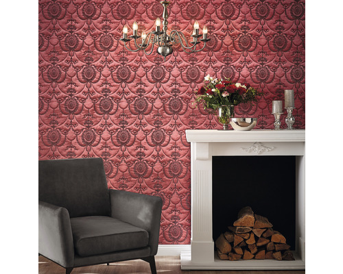 Wohnzimmer mit gemusterter Tapete, Sessel und Kamin