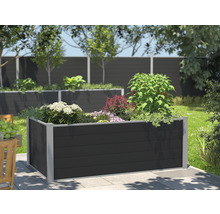 Hochbeet aus Kunststoff mit verschiedenen Pflanzen in einem Garten.